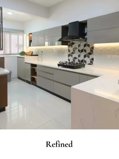 This kitchen blends modern style with everyday practicality. The geometric tile backsplash behind the stove adds a fun, graphic element, while the sleek grey cabinets and white countertops keep the look clean and refined.