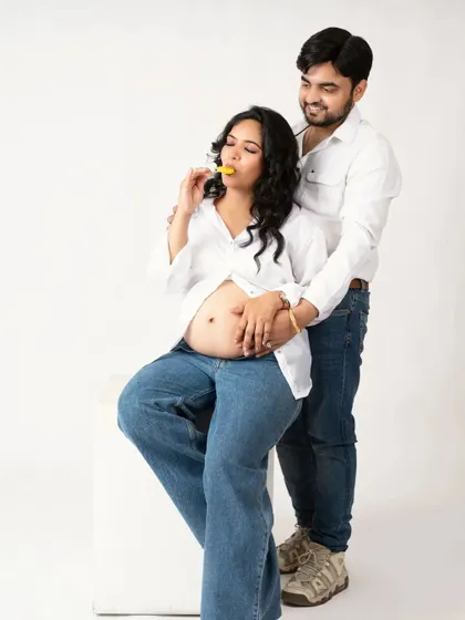 A cute and candid moment. The couple shares a lollipop, a fun and lighthearted way to capture their connection.