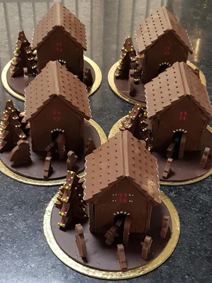 A batch of my chocolate Christmas huts ready for pickup from the workshop. Each one is a substantial, fully edible sculpture perfect for a grand holiday display.