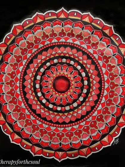A close-up of the red, black, and white mandala. This view shows the detailed patterns and the different shades of red that give the piece its depth.