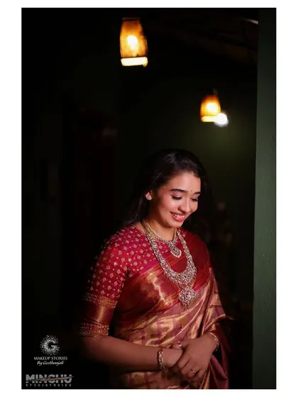 Priyanka looking down, with a soft smile. Her makeup is flawless and radiant, creating a look of pure elegance for her post wedding celebration.