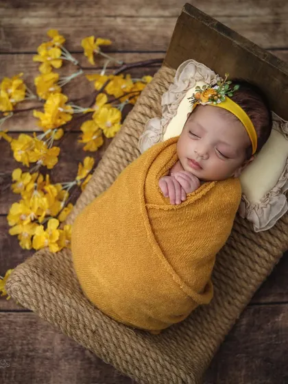 A peaceful sleeping portrait on the rustic jute bed. The soft pillow and cozy wrap ensure the baby is comfortable and secure throughout the session.