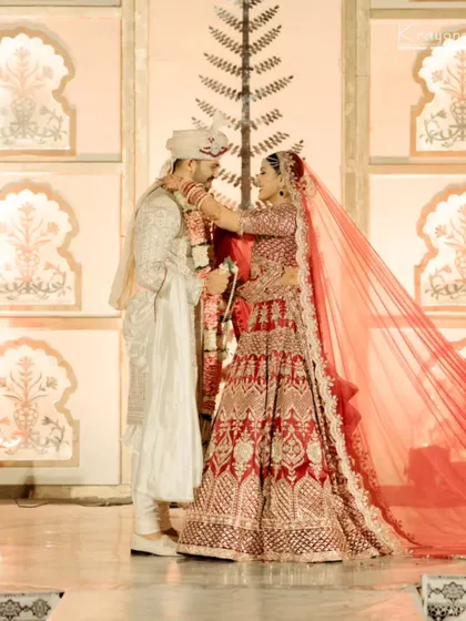 A tender moment during the varmala ceremony, as the bride lovingly places the garland on the groom.
