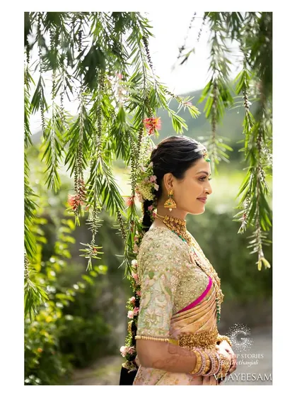 A beautiful profile of my bride Ashitha, with her floral braid catching the sunlight. Her wedding makeup was soft and romantic, perfect for the outdoor setting.