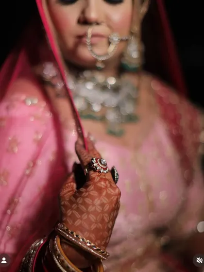 A close-up on the details. This artistic shot focuses on the bride's henna-adorned hand and her beautiful ring, with her face softly blurred in the background.