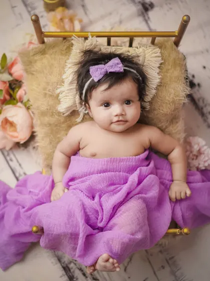 A little princess in her purple bed. This awake shot captures a beautiful, curious expression.