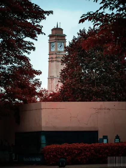 A clock tower framed by deep red foliage. I use color and framing to create artistic and moody shots of city landmarks.