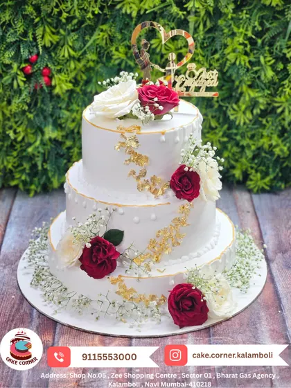 This is a classic three-tier anniversary cake, decorated with fresh red and white roses and a touch of gold leaf. It’s simple, beautiful, and perfect for celebrating your love story, whether it's for a wedding or an anniversary.