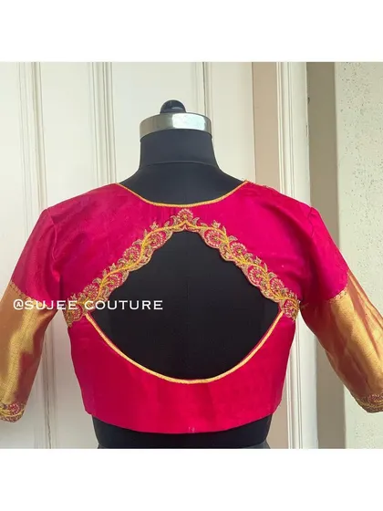 A simple and elegant pink blouse with a large circular back cutout. The cutout is framed with delicate gold embroidery, and the sleeves are a contrasting gold brocade.