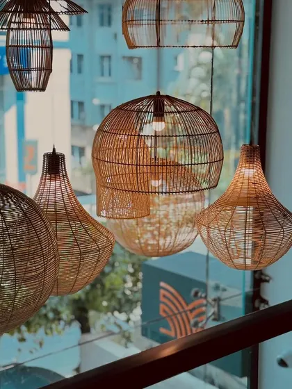 Our collection of handcrafted wicker pendant lights adds a touch of rustic, coastal charm to the modern interiors, casting a warm and inviting glow over the dining space.