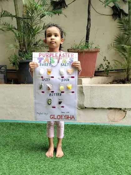 Standing proudly in our outdoor area, this student shows off her detailed taste chart. This project encourages children to explore different foods and connect them to the five basic tastes.