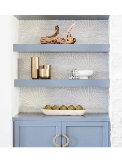 Wallpaper doesn't always have to cover an entire wall. Here, the 'Palm Frond' wall covering is used to line the back of shelves, adding a pop of pattern and colour to this beautiful blue cabinetry.