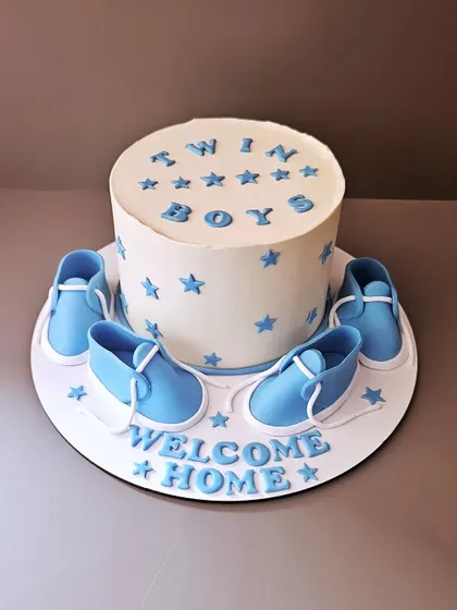 Welcoming home twin boys with this adorable cake. The design features four tiny, handcrafted baby booties, perfect for celebrating the arrival of two little miracles.