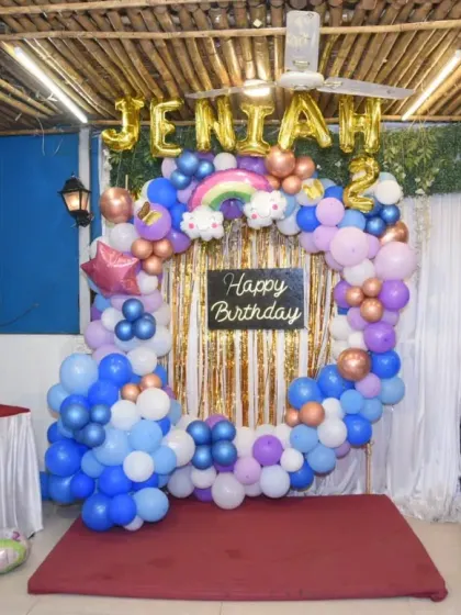 The full view of the birthday party decor, featuring a circular balloon arch and a "Happy Birthday" sign.