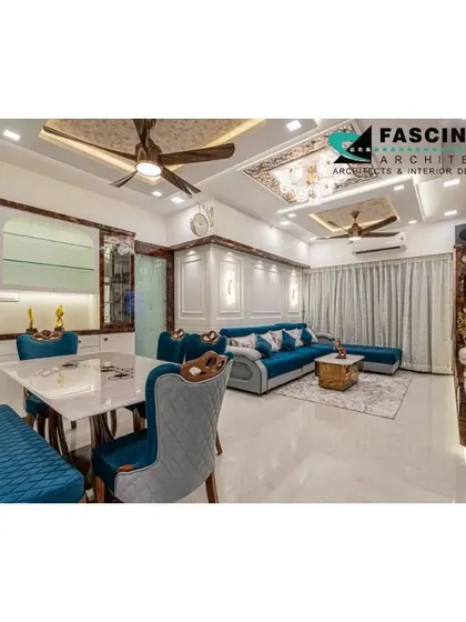 A wide view of the luxurious living and dining space at a Lodha Belair project. The design integrates a vibrant blue sofa with ornate dining furniture and a custom ceiling, showcasing our ability to blend bold colors with classic elegance.