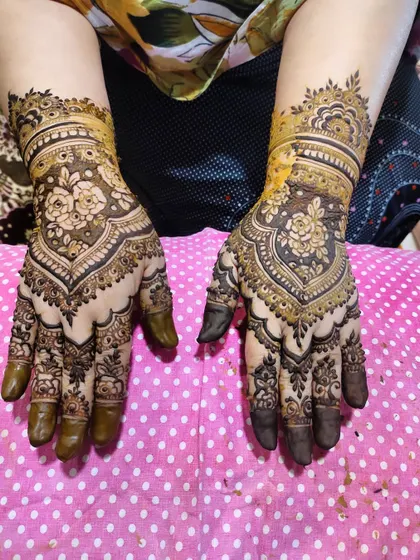 A gorgeous design with a central floral mandala and intricate wrist work.