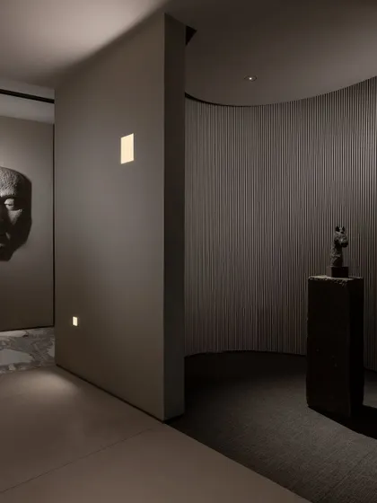 We use lighting to create distinct zones and moods. Here, wall-washing lights and focused spotlights draw attention to art pieces and architectural details, guiding the visitor's journey.