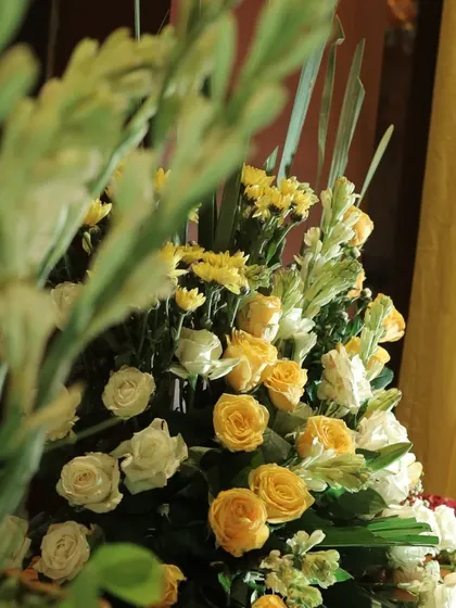A close-up of a beautiful floral arrangement with yellow and white roses, a key component of the Haldi decor theme.