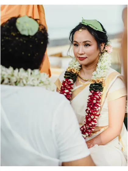 A beautiful over-the-shoulder shot of the bride looking at her groom during their South Indian wedding ceremony.