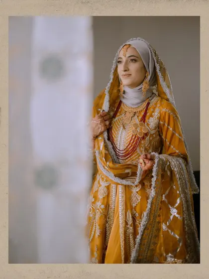 A classic portrait of the bride Insha, framed by a window, looking elegant and thoughtful in her traditional attire.