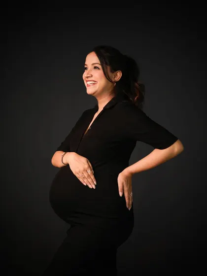 A joyful and confident solo portrait against a classic dark backdrop. Her smile says it all.