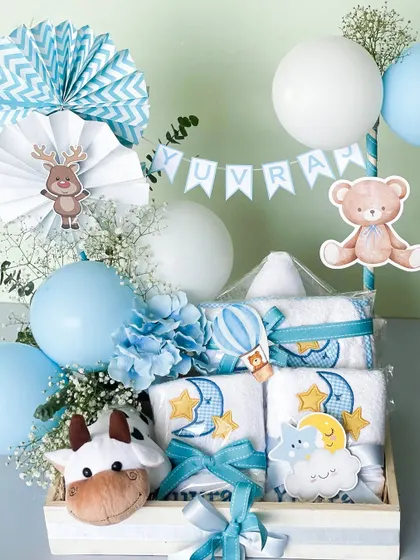 Another view of the baby boy hamper for Yuvraj, showing the cute cow and reindeer details, along with the moon-and-stars themed towels, all tied together with blue ribbons.