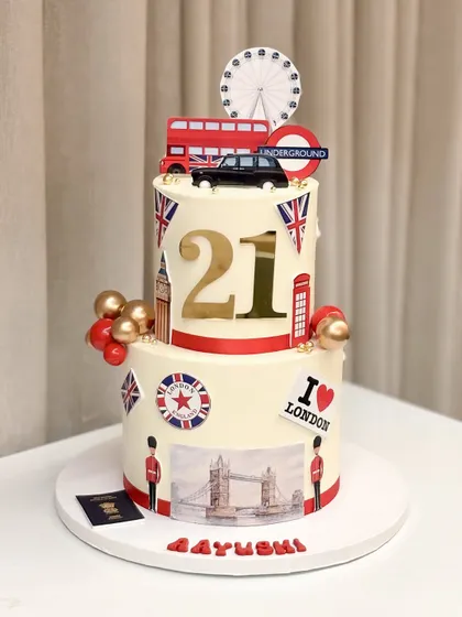 A 21st birthday cake full of London dreams! This two-tiered cake is decorated with iconic London landmarks like the red bus, Tower Bridge, and the London Eye to celebrate a new journey.