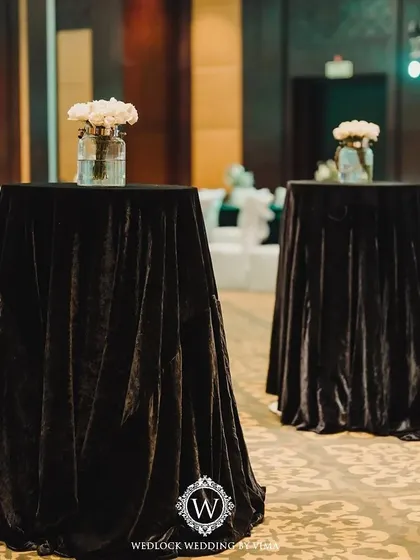 An elegant centerpiece for a Sangeet night, featuring white florals, baby's breath, and candles on a mirrored tray. The mini disco balls add a touch of sparkle and fun, tying into the party theme.