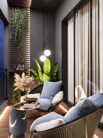 This image captures a modern balcony at dusk, highlighting the importance of ambient lighting. Floor-level strip lighting and soft pendant lights create a warm, inviting glow on the wicker chairs and wooden deck, perfect for a quiet evening outdoors.