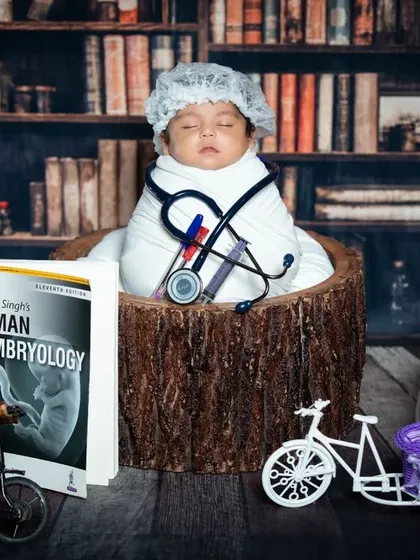 A slightly different angle of our studious newborn doctor, showing the variety of props used to create this intellectual scene.