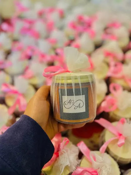 Holding one of the personalized candles for Apoorva and Aditya's wedding, showing the custom monogram.