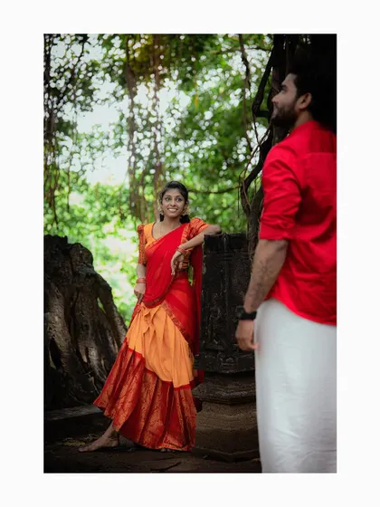 A beautifully composed shot with the groom-to-be in the foreground and his partner posing by ancient ruins.