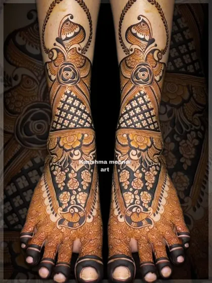 An elaborate design for bridal feet with a focus on floral and peacock motifs. The use of dark, bold lines creates a striking contrast and ensures the intricate details are clearly visible.