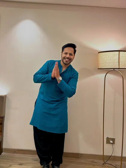 A welcoming 'Namaste' in the teal kurta. It's a simple gesture that builds an instant connection with the audience.