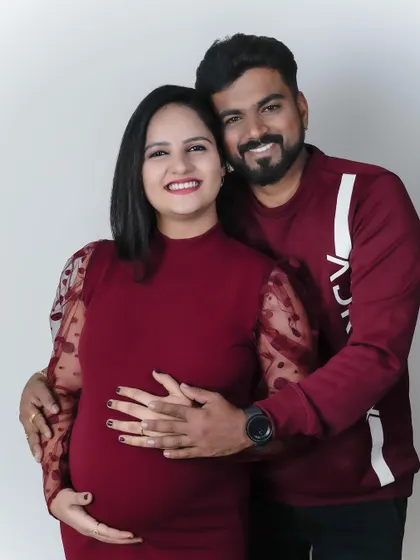 A modern and chic studio look. This couple chose matching burgundy outfits for a stylish and contemporary maternity portrait series.