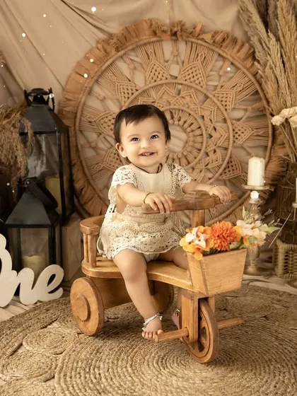 A first birthday shoot with a rustic, bohemian theme. The natural textures of wood, jute, and dried grasses create a warm and earthy setting for this little one's portraits.