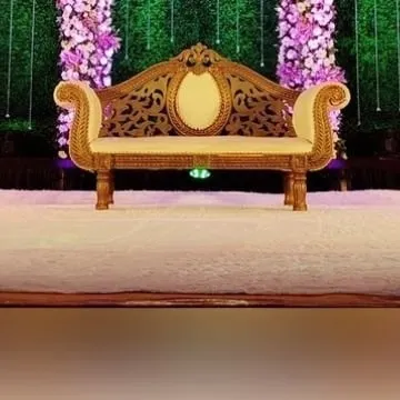 The seating for the couple should be just as special as the backdrop. This ornate, gold-finished sofa provides a regal and comfortable spot for the bride and groom on their big day.
