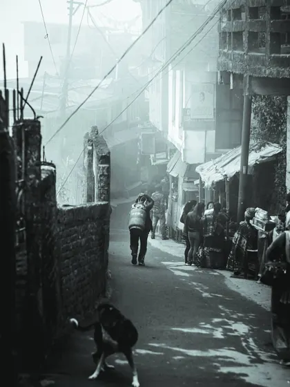a black and white photo of a foggy alley. the depth and layers in this street scene are similar to how i approach layering elements in a user interface.