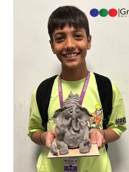 Another happy student from our school workshop, proudly displaying the Ganpati idol he sculpted himself. These workshops help build confidence and a sense of accomplishment.