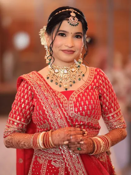 A close-up of a real bride in her red wedding attire, showcasing the beautiful jewellery and her happy smile.