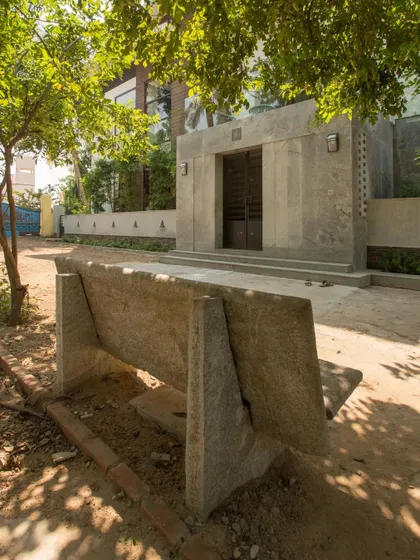 A custom-designed concrete bench provides seating in the front yard, turning a simple outdoor space into a functional rest area.