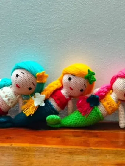Three beautiful mermaids relaxing together. Each one is handmade with high quality, colorful yarn.