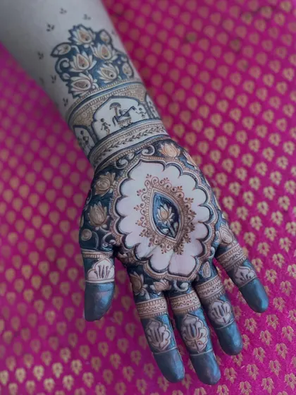 A stunning design with a central lotus blooming in a decorative frame. The dark, bold henna application makes the design truly stand out.
