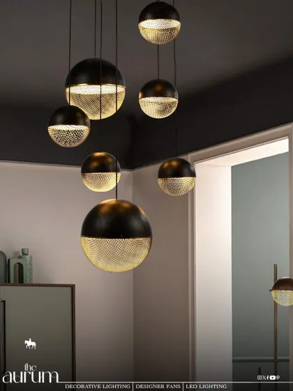 I love playing with contrast. This cluster of modern pendant lights, with their dual-tone black and perforated gold finish, creates a dramatic and moody atmosphere. They are perfect for adding a touch of sophisticated, masculine energy over a dining area or in a lounge.