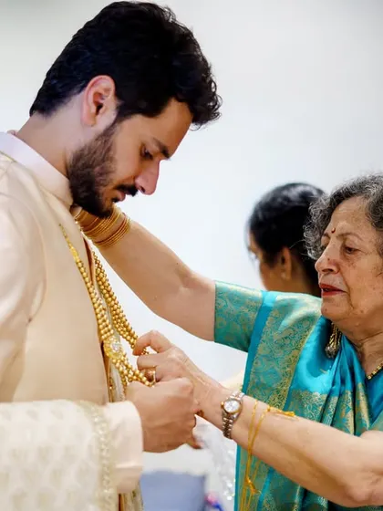 A close up of Akshay's aunt helping him with his jewelry. These moments of family connection are so important to capture on the wedding day.