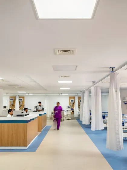 This dialysis ward, part of an adaptive reuse project, is designed for operational efficiency and patient comfort. The layout provides staff with clear sightlines and easy access to patients, while the clean aesthetic promotes a sense of calm.