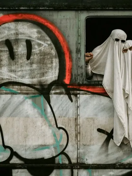A close-up of the ghost couple peeking out the bus window, with a focus on the graffiti.
