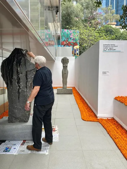 The artist Stephen Cox himself tending to his sculpture at the museum preview. This moment captures the collaborative spirit of the project, where the architect, artist, and institution work together to bring the space to life.