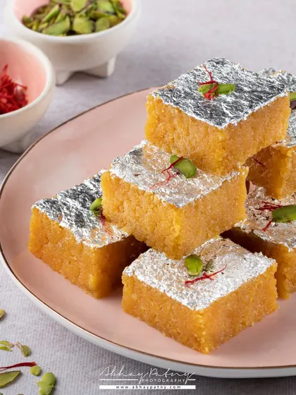 This stack of Mohanthal is shot to emphasize its texture and richness. The silver vark (edible foil) catches the light, adding a touch of luxury and festivity to this classic Indian sweet.