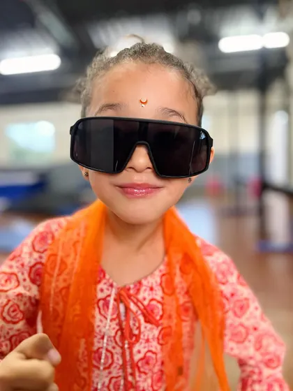 Capturing hearts with that pretty girl charm. A student shows off her cool side with oversized sunglasses during a dress-up day.